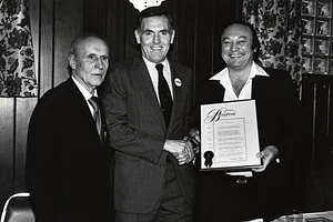 Mayor Raymond L. Flynn presenting a proclomation with two unidentified men