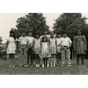Group portrait of ten unidentified children standing in a park.