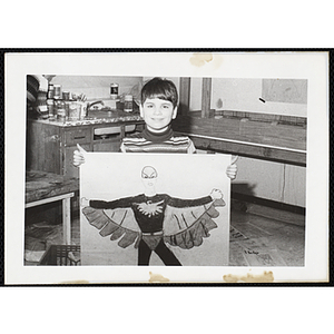 A boy displaying a drawing for his art class at the South Boston Boys and Girls Club