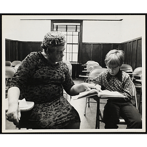 A woman tutors a boys in a classroom