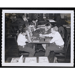 Boys play checkers in a library