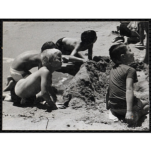 Five boys play in the sand on a beach
