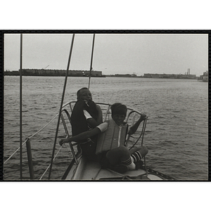 Several boys sitting and smiling in the bow of a boat