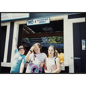 Two girls and a boy stand in front of the Water Country water park intertube exchange window at a Tri-Club field trip