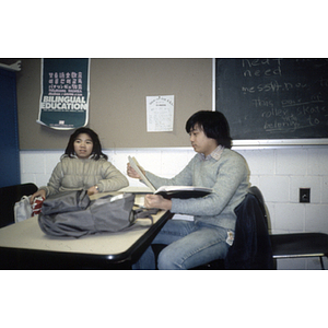 Two Chinese Progressive Association youth sit at a desk in a classroom