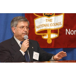 George Chryssis speaks into a microphone at The National Council Dinner