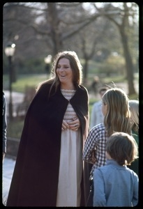 Judy Collins, wearing a full-length cloak, standing with children