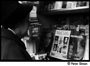 Woman looking at magazines at a Cambridge newsstand