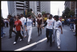 Marchers in the San Francisco Pride Parade, wearing politically-charged t-shirts 'Reagan is killing me', 'Morality means saving lives', and '$ for kids, not Contras'