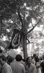 Gay liberation demonstration at Cambridge Common: man hanging Gay Liberation Front flag