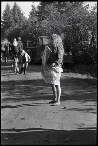 Woman in a peasant dress and other communards walking along a dirt road, Earth People's Park