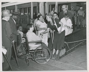 Man in wheelchair shakes hands with woman