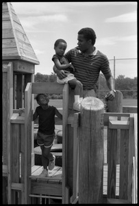 Rory McClaurin with children atop playground equipment