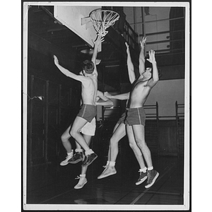 Four men jumping and reaching for basketball hoop