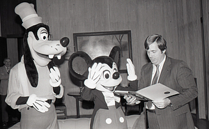 Man with Disney characters Mickey Mouse and Goofy