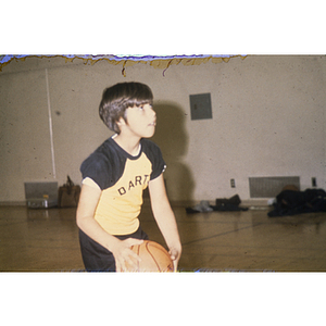 Child playing basketball in gym