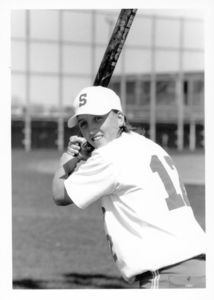 Suffolk University women's softball player Kate Norton (#12), poses with bat in the field, circa late 1990s