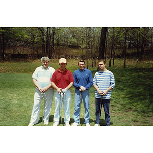 A four-man golf team posing on the golf course at a Boys and Girls Club Golf Tournament