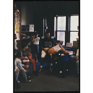 A girl posing with a football player while others look on at a Boys & Girls Club awards event