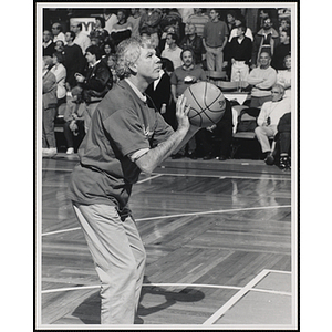 Boston Globe sports columnist Bob Ryan preparing to shoot a basketball at a fund-raising event held by the Boys and Girls Clubs of Boston and Boston Celtics