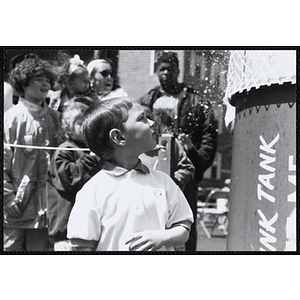 A boy looks up at a dunk tank at the Boys and Girls Clubs of Boston 100th Anniversary Celebration Street Fair