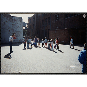 A man plays a ball game with children at a carnival