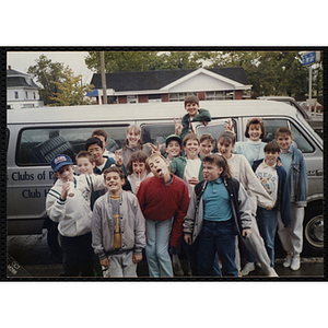 A group of children gather for a group shot next to a Boys and Girls' Club of Boston van