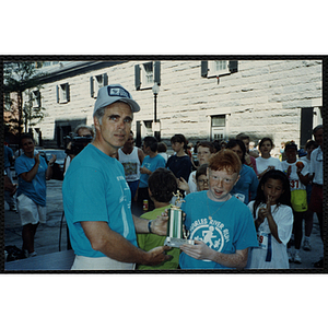 A man and a girl pose with a trophy at the Battle of Bunker Hill Road Race