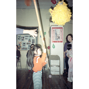 Young girl prepares to hit a piñata at the Chinese Progressive Association Lunar New Year celebration