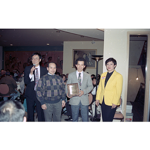 Two men holding an award at a celebration of the Chinese New Year, hosted by the Chinese Progressive Association