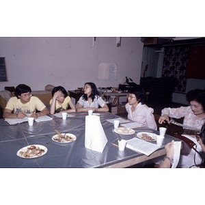 Suzanne Lee and other members of the Chinese Progressive Association eat at a table at the organization's office