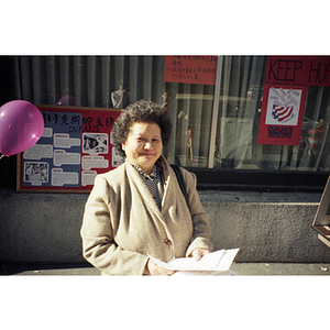 Woman in Chinatown takes information about Michael Dukakis and the upcoming presidential election on Nov. 8, 1988