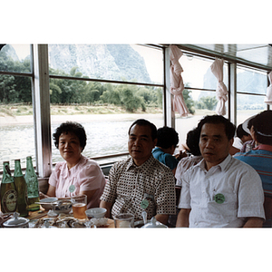 Two men and a woman on a boat cruise through Guilin, China