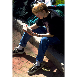 Student reading a book on the Northeastern campus