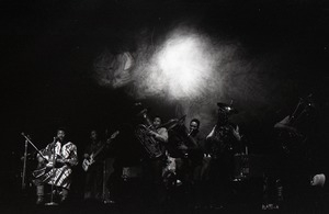 Taj Mahal in concert at Northfield, Mass.: Taj Mahal (guitar) and horn section with light show behind