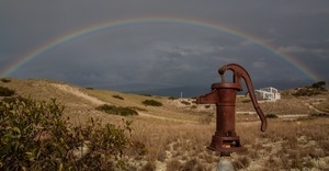 Water pump set against a rainbow over the dunes at Fowler Dune Shack, Provincetown