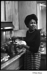 Party at Jackie Robinson's house: David Robinson feeding a baby with a  bottle, December 22, 1963