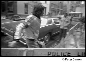 Grateful Dead crew member(?) walking past police barriers on the New York streets