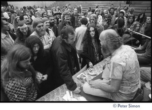 Ram Dass seated on stage at the College of Marin, talking to audience members