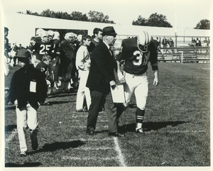 Victor M. Fusia conferring with football player