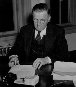 John K. Broadfoot sitting at desk