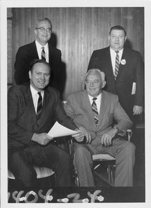 John W. Lederle standing indoors with three unidentified men of the Massachusetts House Ways and Means Committee
