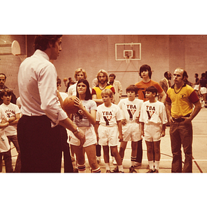 Basketball coach giving instructions to children