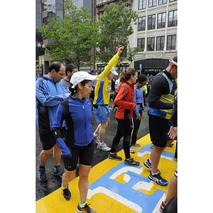 A crowd of "One Run" participants slows as they touch the Copley Square finish line