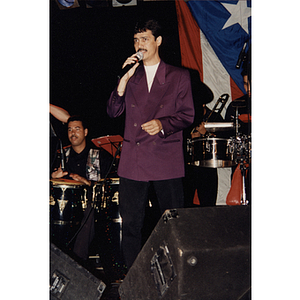 Eddie Santiago sings into a microphone at a Festival Puertorriqueño event