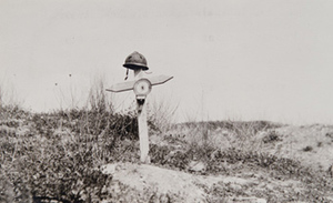 View of a French helmet atop a wooden cross marking a gravesite