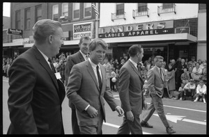 Robert F. Kennedy and entourage walking past Landers Ladies Apparel, during the Turkey Day festivities