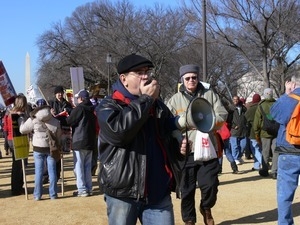 Protesters on the National Mall marching against the War in Iraq, led by a man with a bullhorn