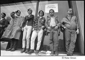 MIT war research demonstration: demonstrators standing by a window outside a building