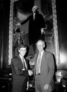 Congressman John W. Olver (right) with a visitor to the capitol, posed in front of portrait of George Washington